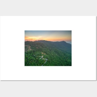 Aerial view of curvy mountain road through a jungle ay sunset Posters and Art